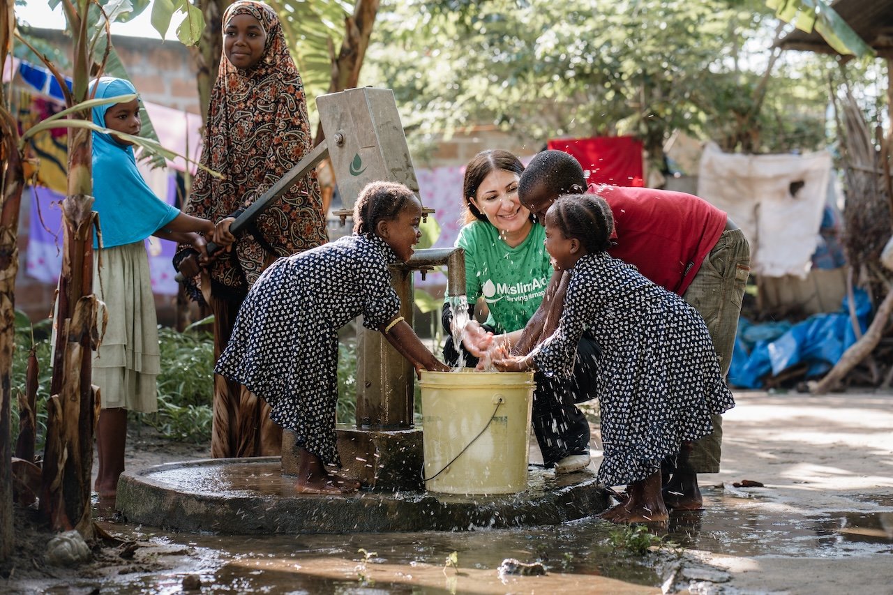 Children and volunteers collecting clean water